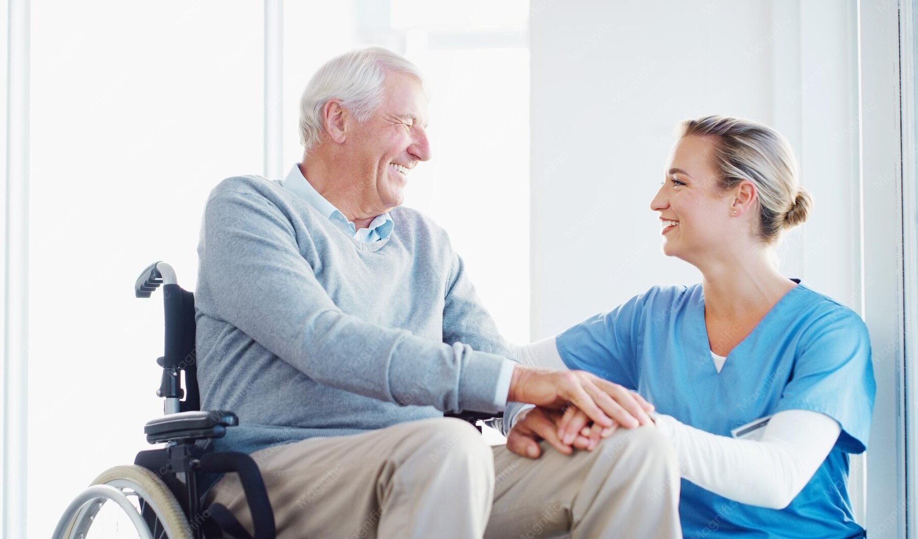 Caring staff member holding a senior resident's hand with an encouraging smile